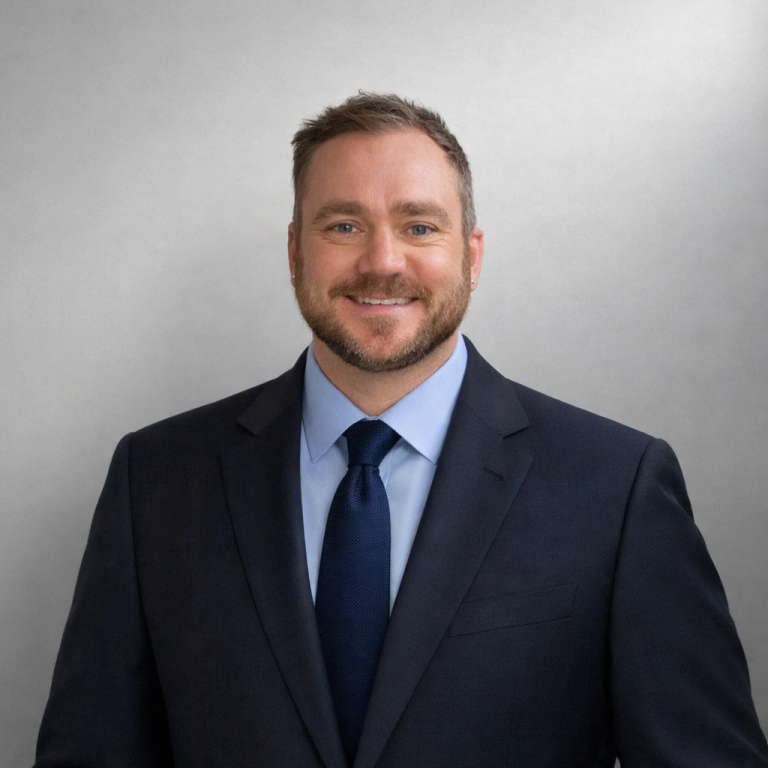 FreightPod Founder, Tom Ball in a suit and tie against a light grey background. Founder, Tom Ball in a suit and tie against a light grey background.
