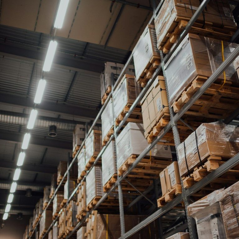 Tall storage racks filled with stacked boxes in a warehouse.